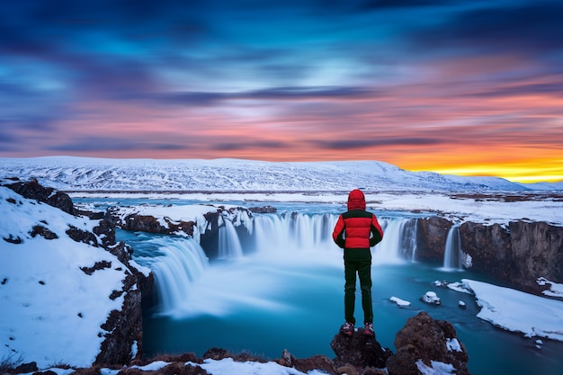 godafoss-waterfall-sunset-winter-iceland-guy-red-jacket-looks-godafoss-waterfall_335224-673